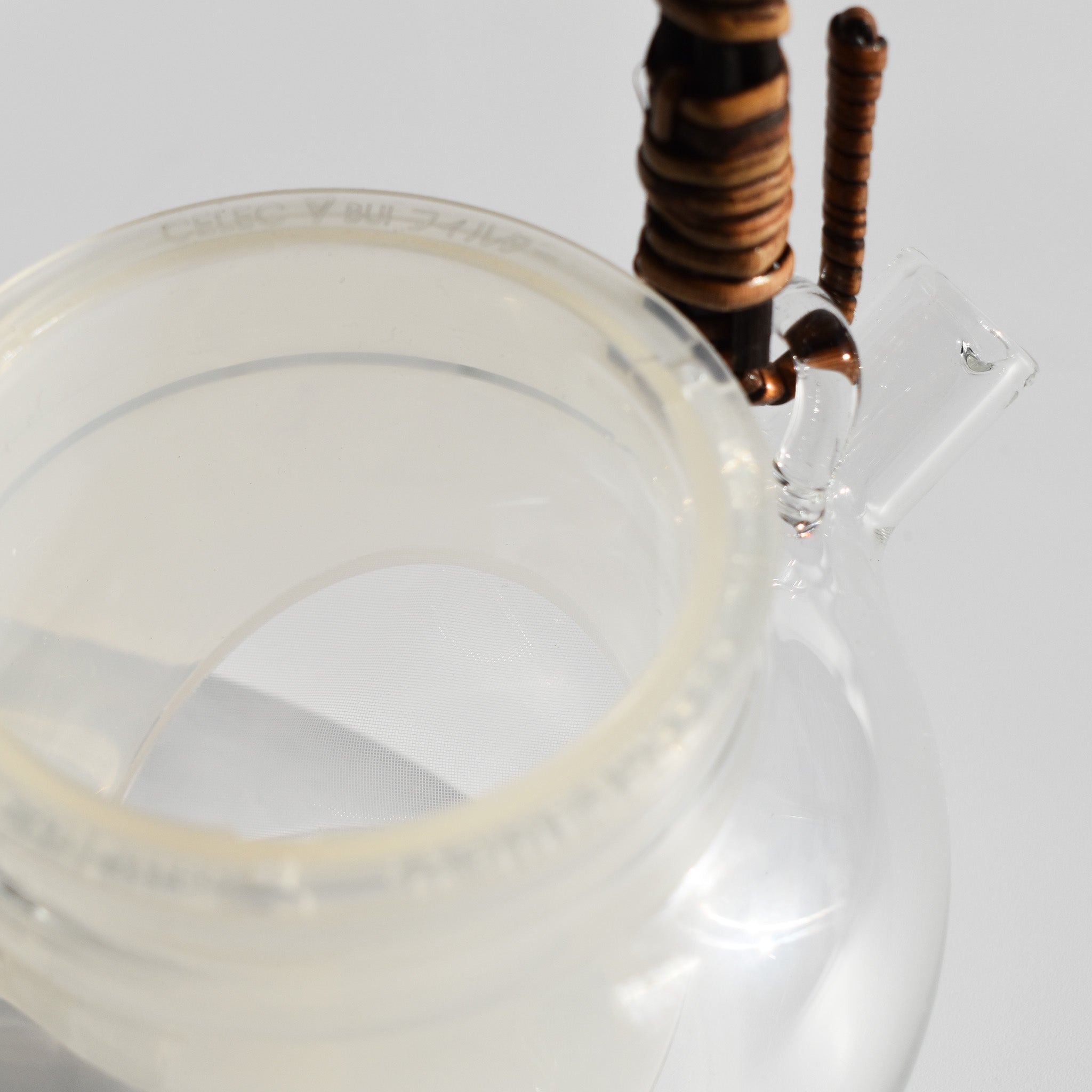 Close-up of glass kyusu teapot with fine mesh infuser and rattan handle, 250ml Japanese loose leaf tea pot.