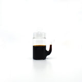 Japanese glass soy sauce dispenser with smooth drip-free spout, filled with soy sauce.