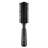 Japanese round hair brush featuring firm black natural bristles and a polished dark wood handle, crafted for smooth detangling and everyday grooming.
