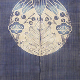 Close-up of Shochikubai noren curtain in indigo featuring pine, bamboo, and plum crest motif, traditional Japanese fabric panel.